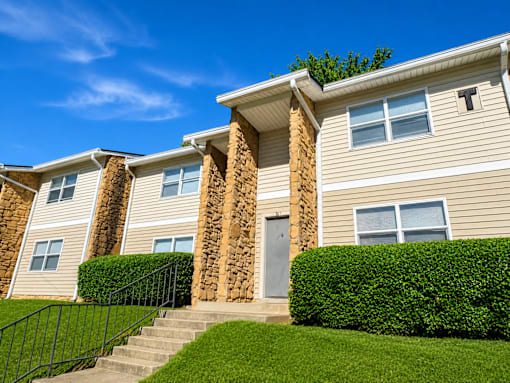 A row of houses with a green lawn in front.