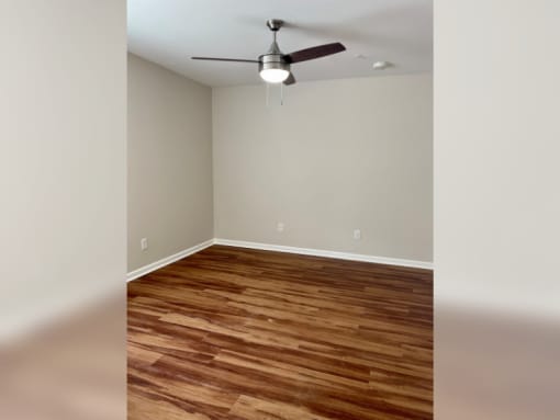 a bedroom with a ceiling fan and hardwood floors