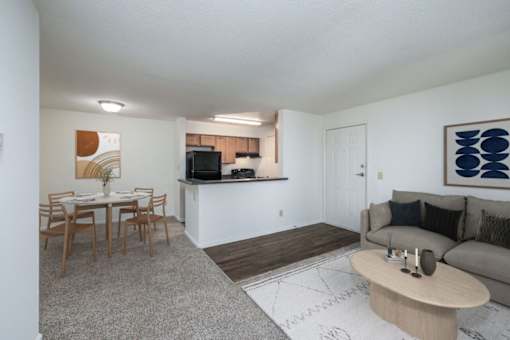 A living room with a couch, a dining table, and a television.