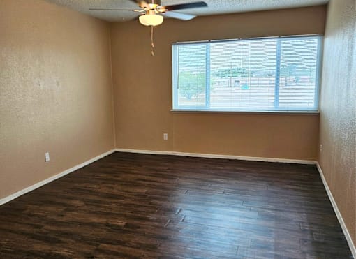 Empty room with a ceiling fan and a window.