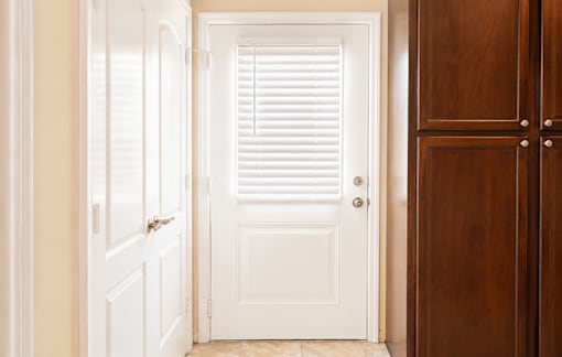 A white door with a brown door on the right.