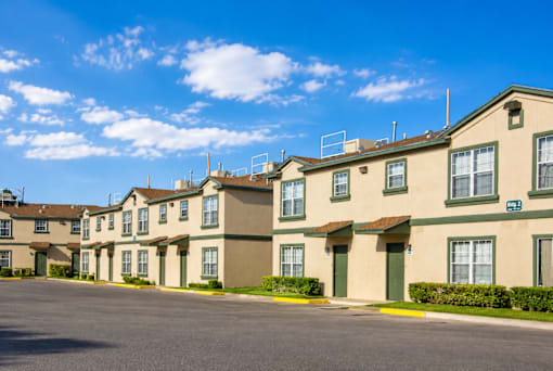 Apartment complex with a parking lot in front.