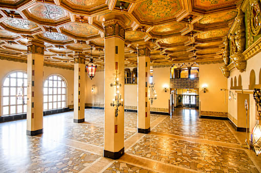 A large room with a stone floor and ornate ceiling.