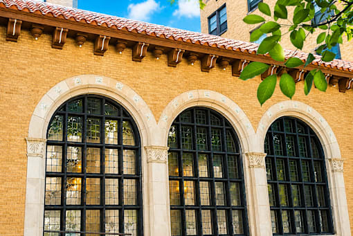 A building with two large arched windows and a red tile roof.