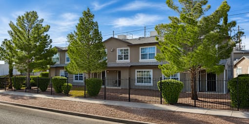 A row of houses with trees in front of them.