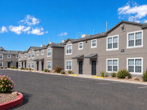 A row of townhouses with a clear blue sky above.