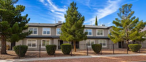 A row of houses with trees in front.