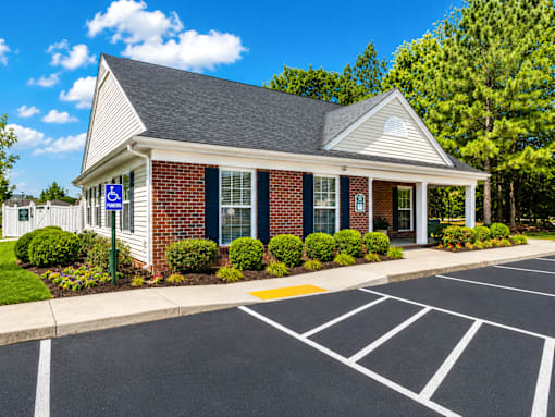 A small building with a parking lot in front of it.