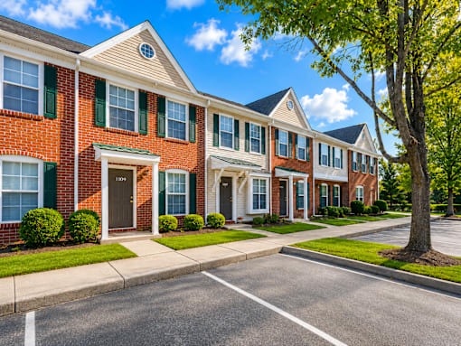 A row of townhouses with green bushes in front.
