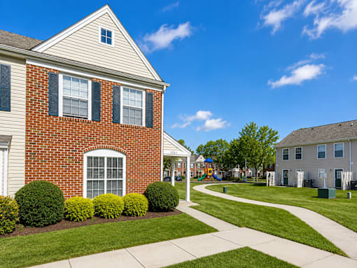 A red brick house with a white window and a white door.