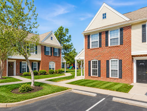 A row of houses with a tree in front of the first one.