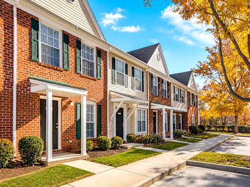 A row of houses with green shutters and white trim.