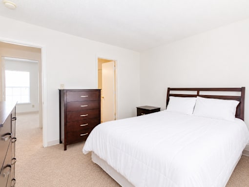 A bedroom with a large bed and a dresser.