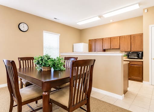 A dining room with a table and chairs.