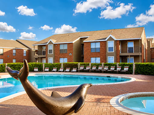 A seal statue is in front of a pool at a residential complex.