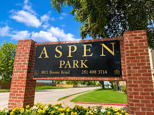 A sign for Aspen Park with a phone number and address.