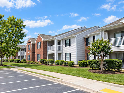 A row of townhouses with a parking lot in front.