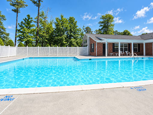 A pool with a house in the background.
