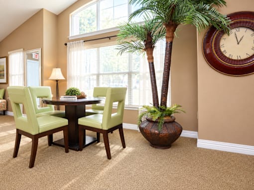 A dining room with a table, chairs, and a clock on the wall.