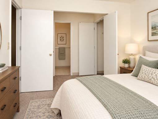 A bedroom with a large bed and a dresser.
