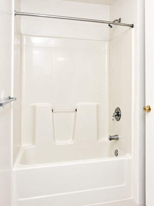 A white bathroom with a shower and a door.