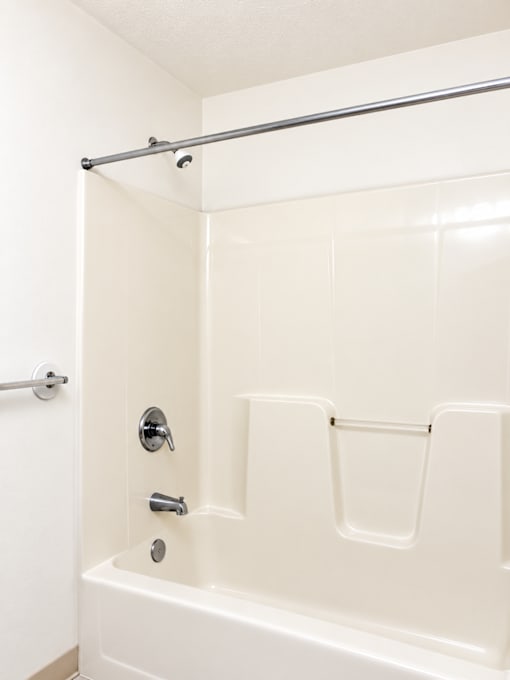 A white bathroom with a tub and shower.