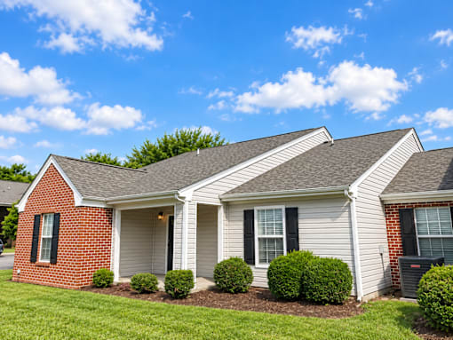 A house with a red brick wall and a grey roof.