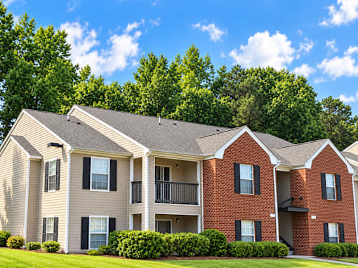 A row of townhouses with a green tree in the background.