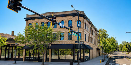 A street view of a building with a blue sign on it.