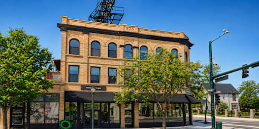 A large building with a black awning sits on a street corner.