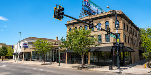 A street view of a city with a traffic light and a building with a sign that reads "The Standard".