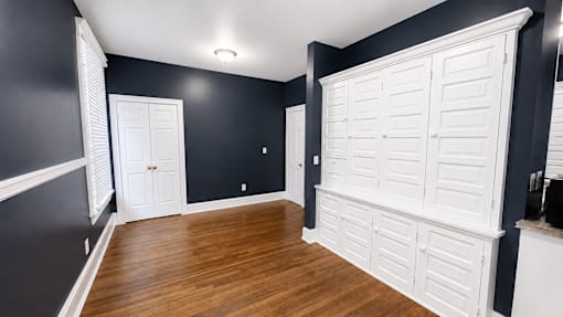 A room with a white door and a white shutter on the wall.