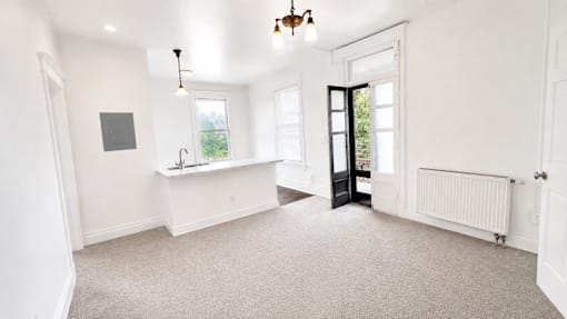 A white room with a window and a radiator.