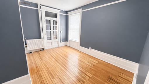 A room with a wooden floor and a white door.