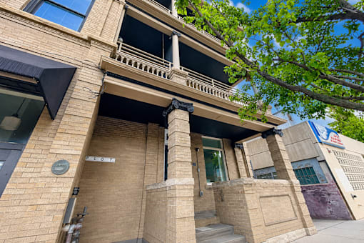 A building with a balcony and a door with a sign that says "ENTRANCE".
