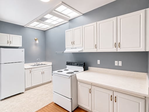 A kitchen with white appliances and cabinets.