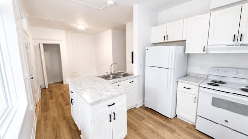 A kitchen with white appliances and cabinets.