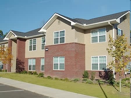 a large brick house with a sidewalk and grass