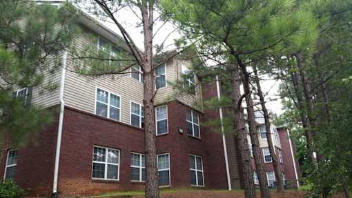 an apartment building with trees in front of it