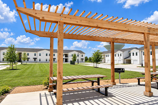 BBQ area with wooden pergola and seating