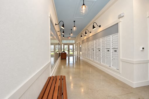 A long hallway with a bench and lights on the ceiling.
