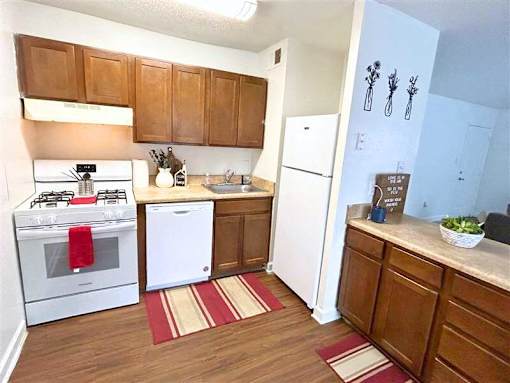 A kitchen with a white stove and a white refrigerator.