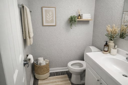 A white toilet sits in a bathroom next to a white sink.
