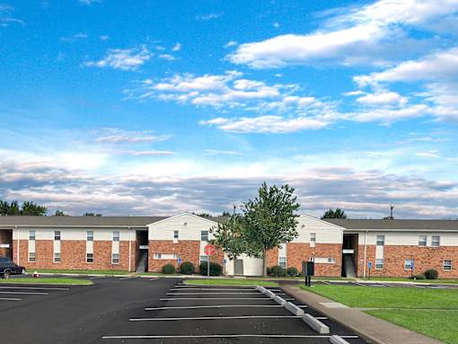 A parking lot in front of a building with a clear blue sky above.