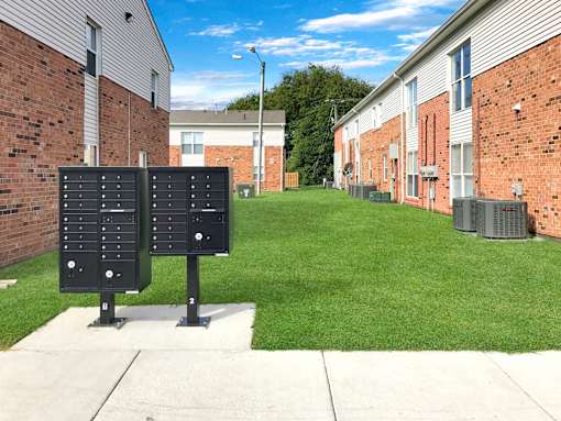 A black panel with white numbers stands in front of a brick building.