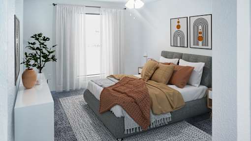 A bedroom with a bed, a plant, and two framed pictures on the wall.