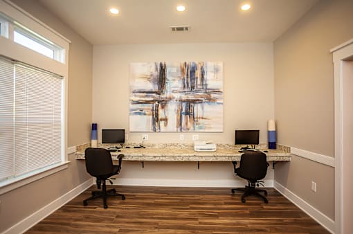 A room with a desk and two chairs.
