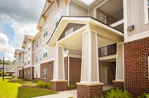 A row of townhouses with a balcony on the second floor.