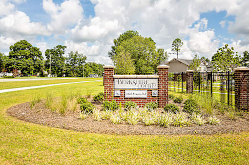 A sign that says Brookhurst Court stands in a field of flowers.