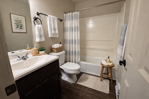 A bathroom with a toilet, sink, and shower.